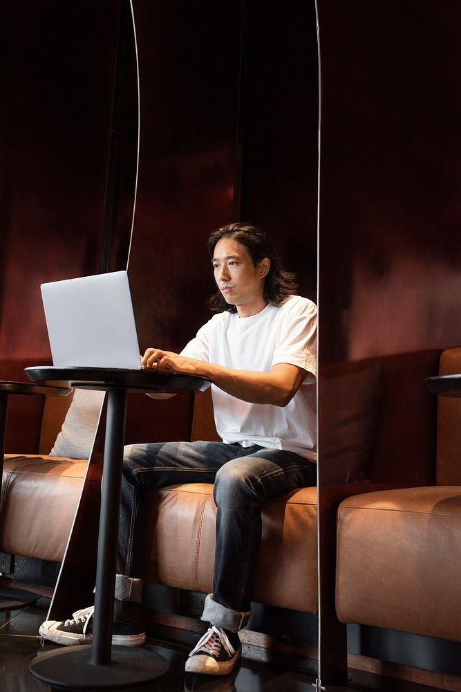 Casual Japanese man working remotely on his laptop
