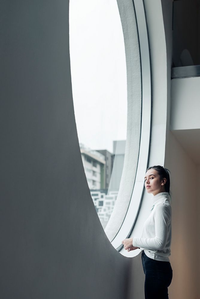 Girl looking out of a modern circular window