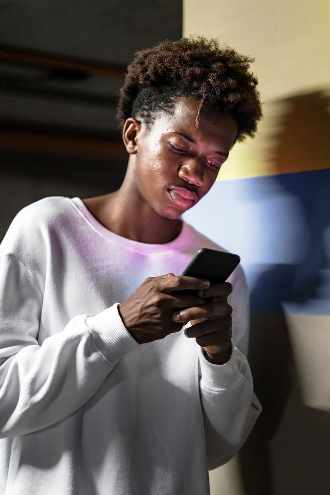 Young man stopping to check social media on his phone