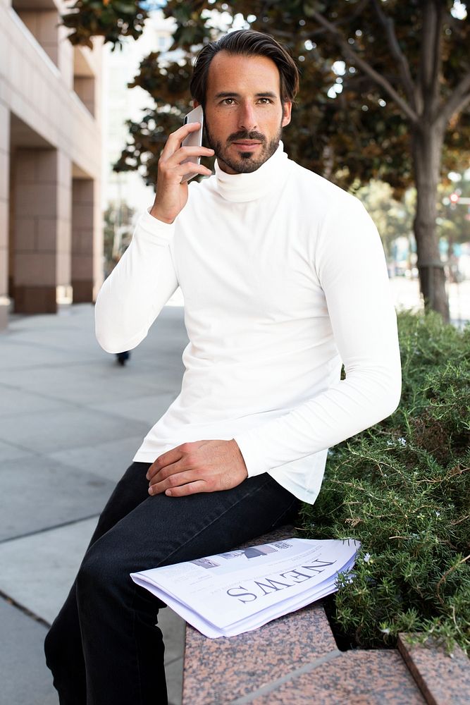 Businessman in turtleneck talking on the phone in the city