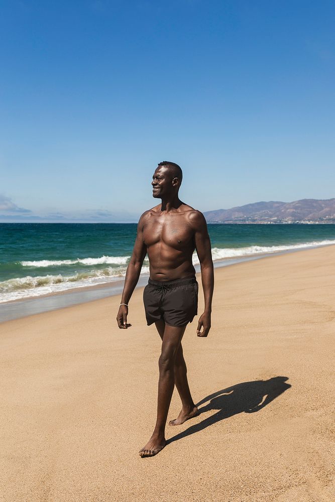 African American man in shorts shirtless summer full body beach shoot