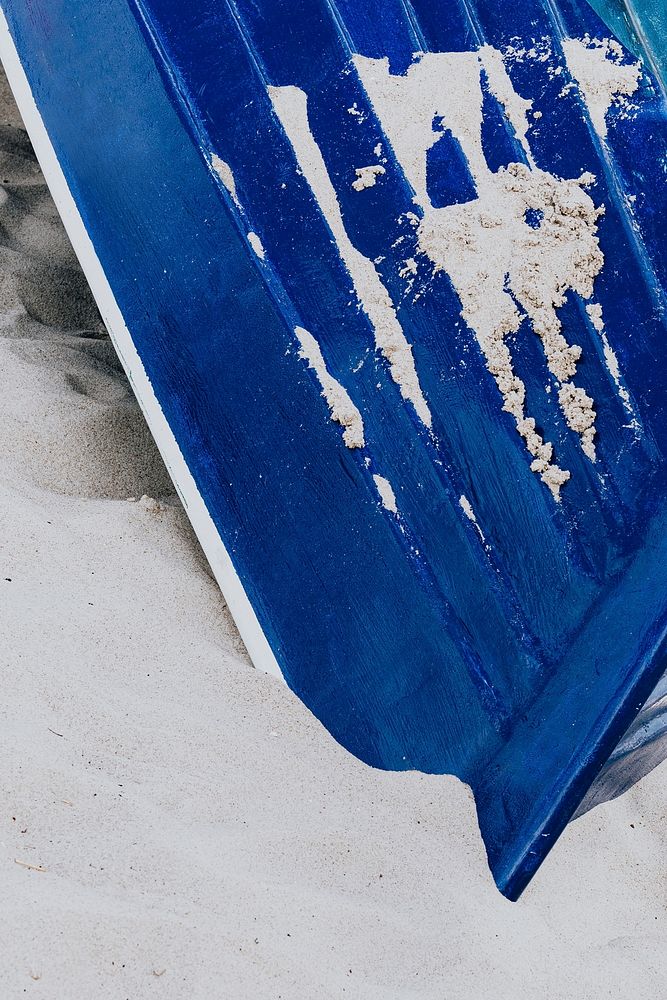 Blue boat lying in the sand on a beach