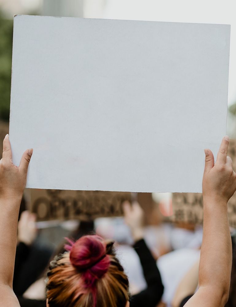 Woman holding a white placard with copy space at a black lives matter protest 