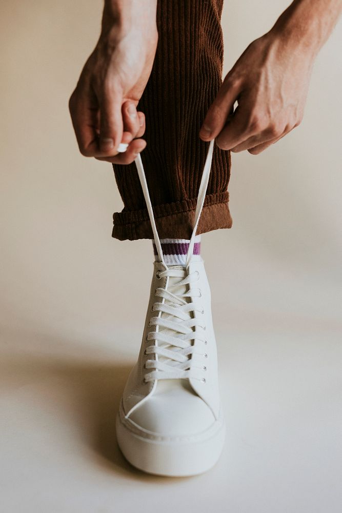 Man hands tying shoelaces white sneaker