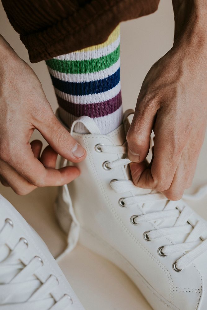 Model tying shoelaces white sneaker