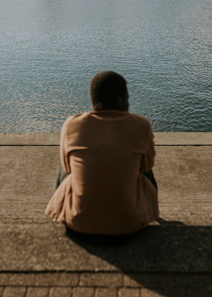 Man sitting alone by the lake