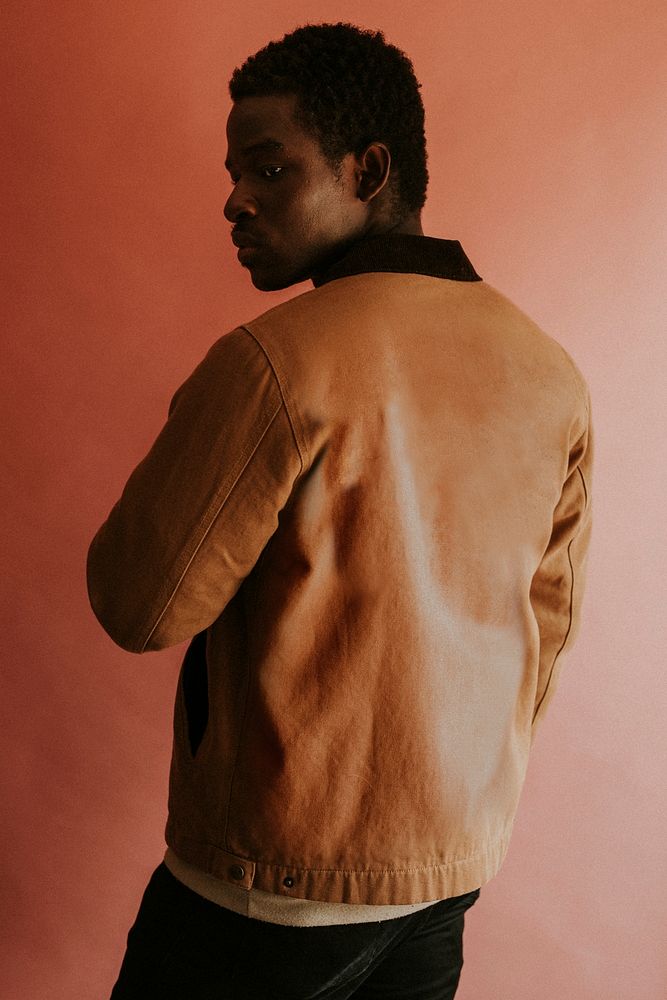 Black man in brown jacket mockup on pink background studio shot