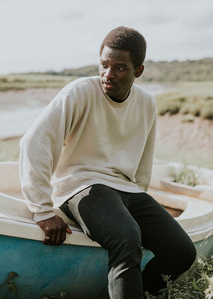 Model in outdoor apparel shoot on a boat by the coast