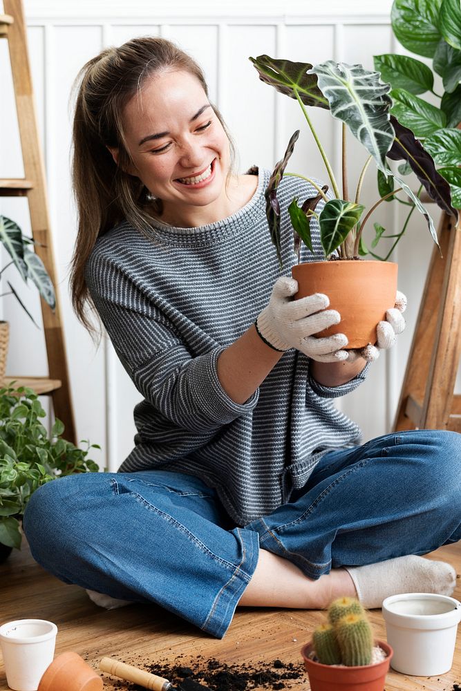 Woman repotting a houseplant inside of her house