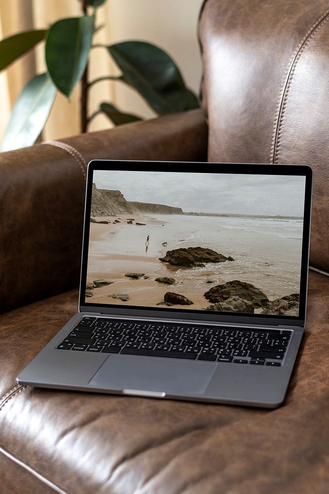 Laptop screen mockup psd on a leather couch