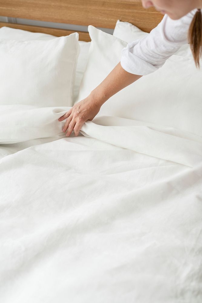 Woman making the bed in the morning