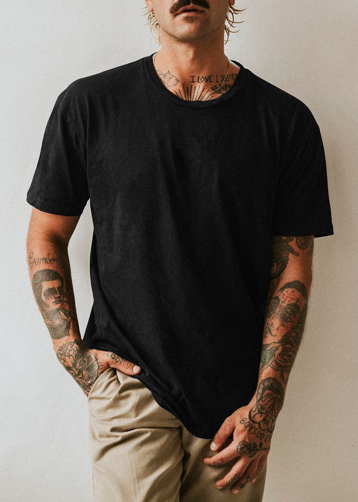 Tattooed man in black tee studio shot
