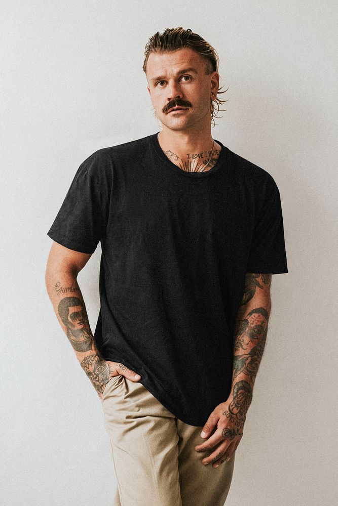 Alternative tattooed man in black tee studio shot