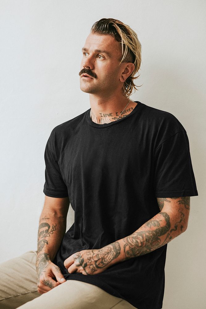 Alternative tattooed man in black tee studio shot