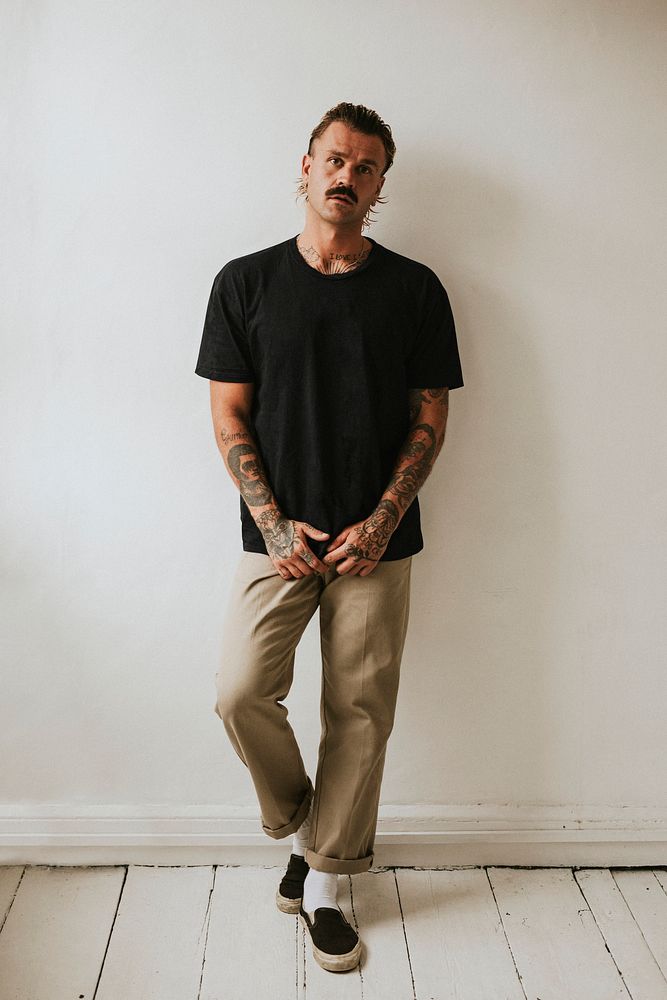 Tattooed man in black tee studio shot