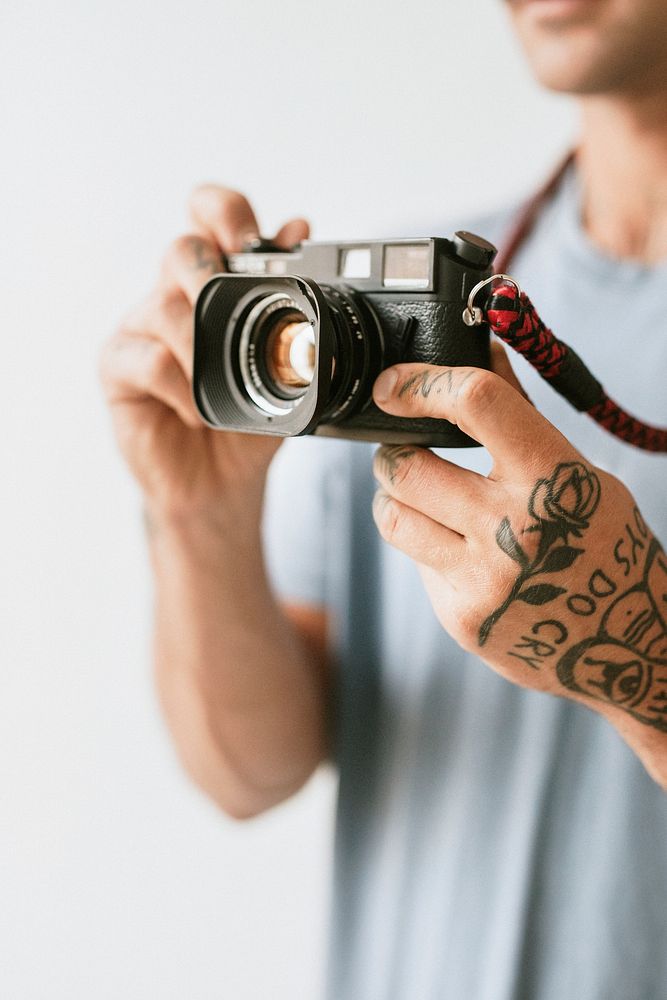 Photographer with tattoos shooting with a film camera