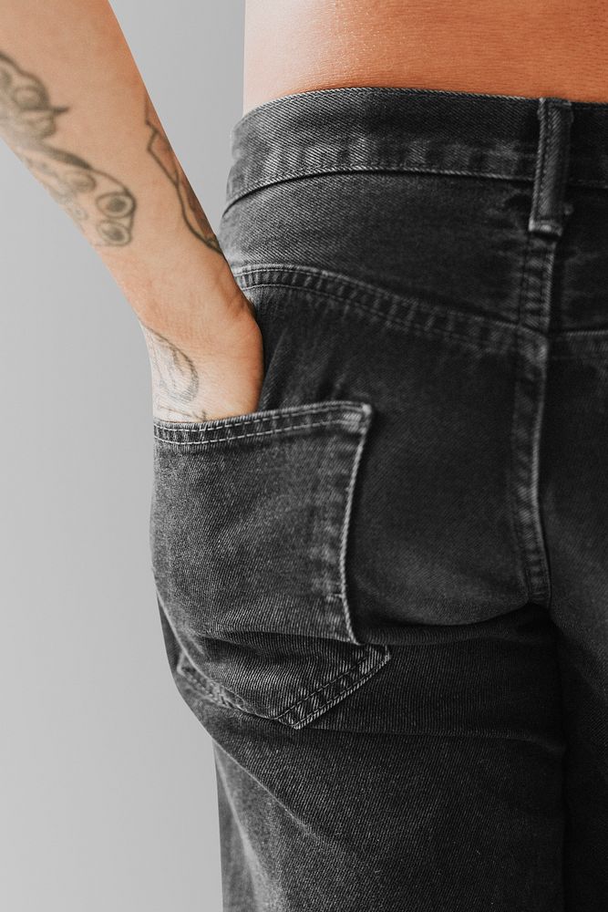 Tattooed hand in a jeans back pocket