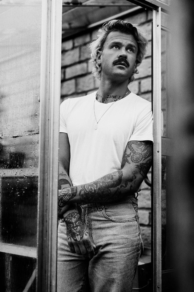 Cool tattooed man in a greenhouse
