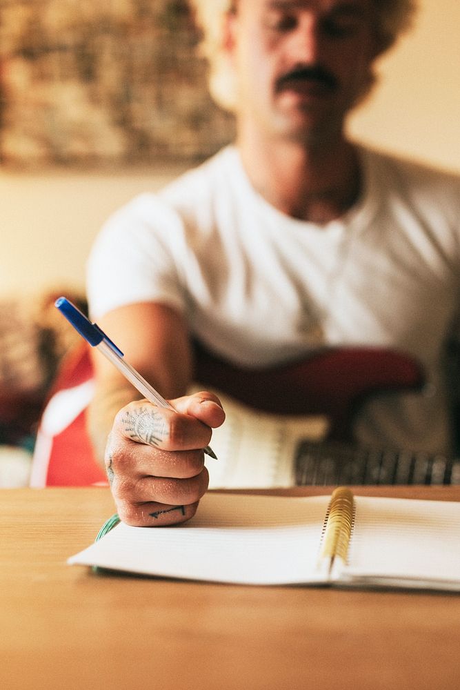 Cool tattooed man writing a new song