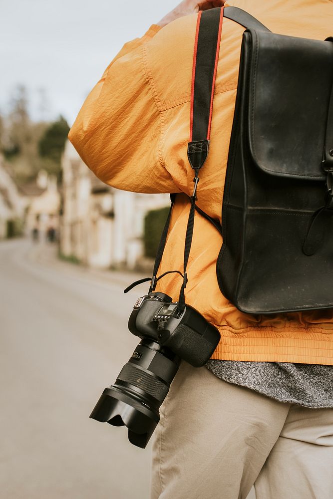 DSLR camera with strap hanging on photographer’s shoulder