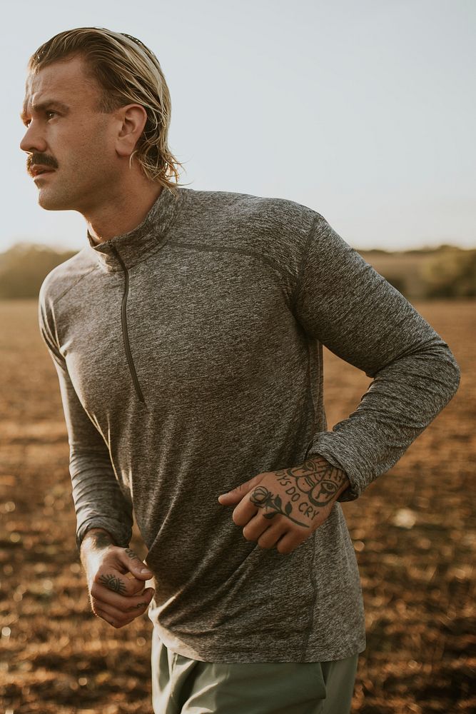 Active man in sportswear running in the countryside
