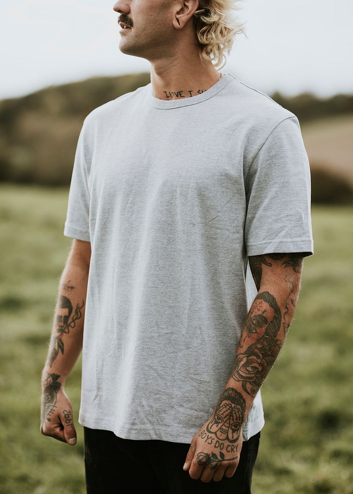 Attractive man in gray t-shirt with design space in countryside