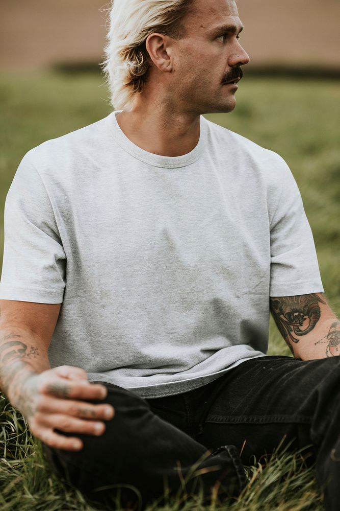 Attractive man in gray t-shirt with design space in countryside
