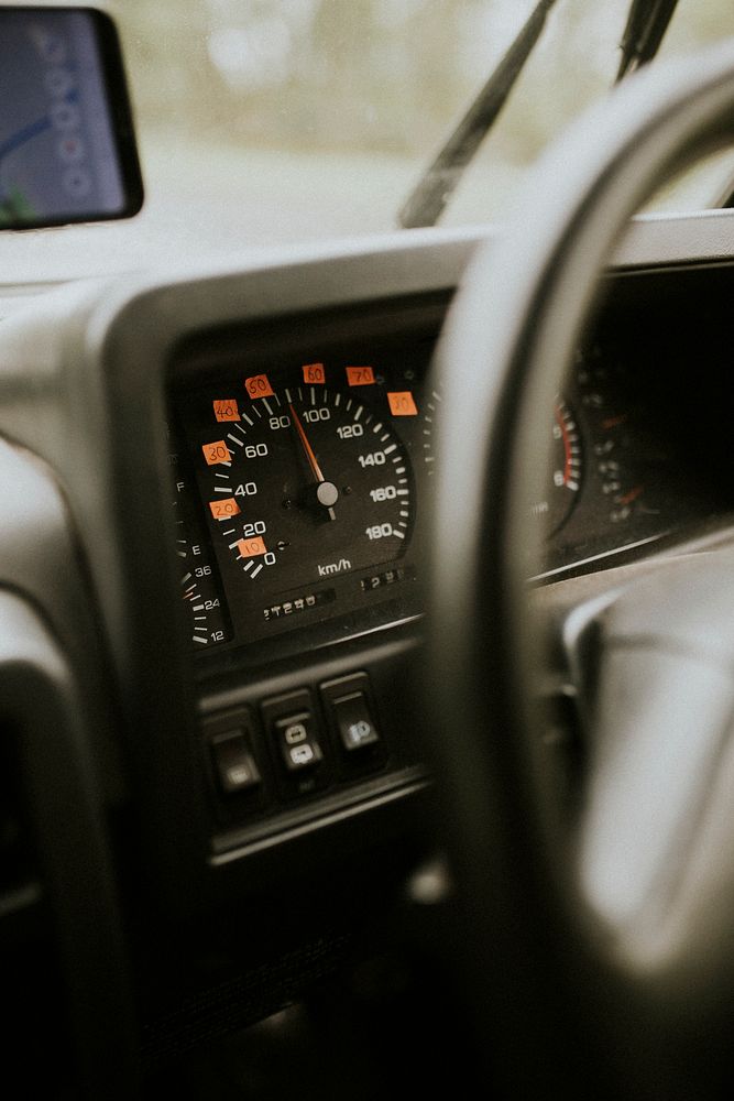 Car steering wheel and labeled speedometer