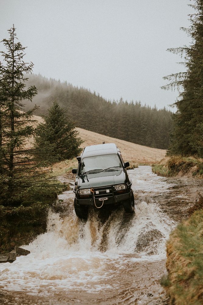 Off-roading car stuck in the water stream in nature