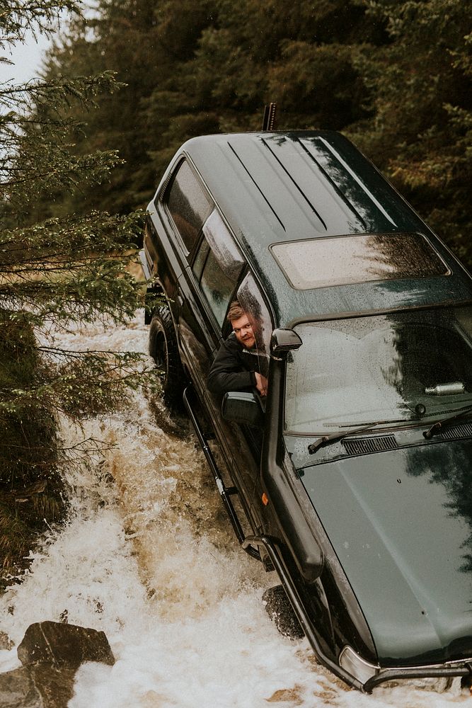 Car stuck in a mountain stream during off-roading road trip