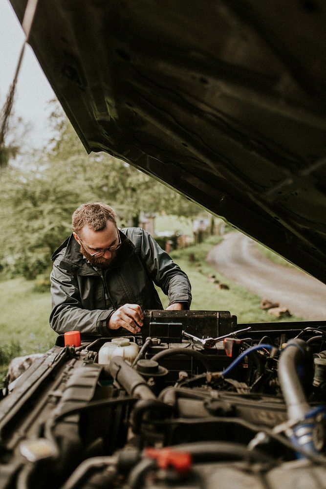 Mechanic fixing a car outdoors auto repair service