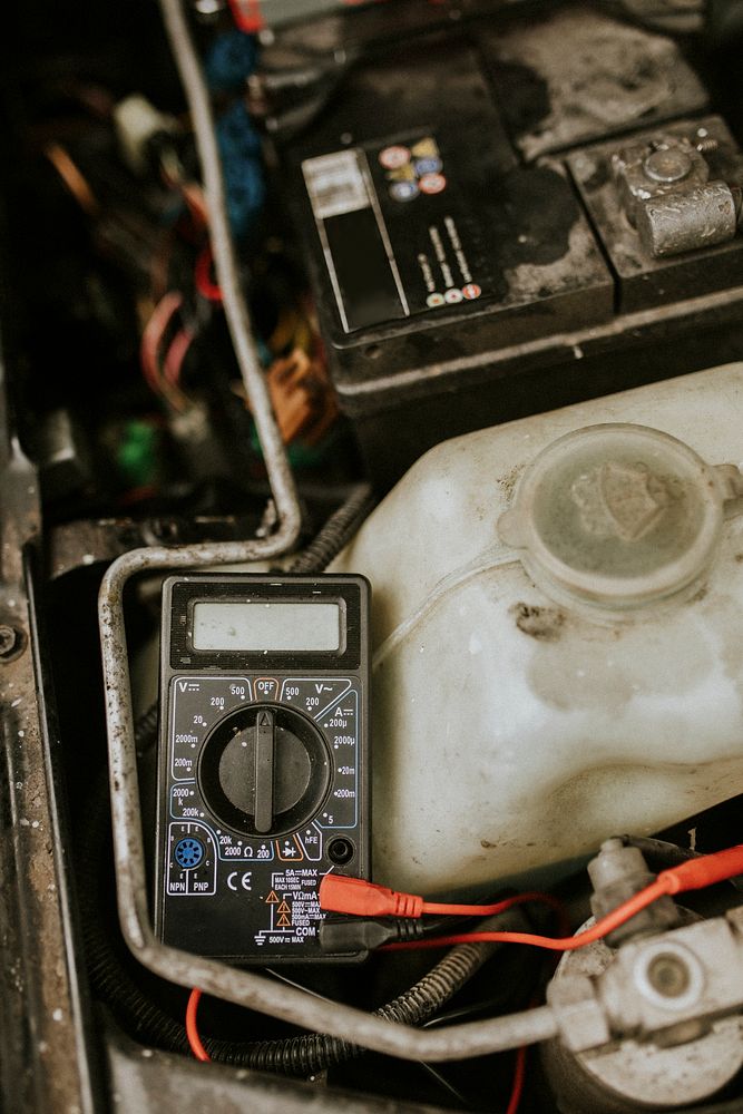 Auto repair using a voltage meter on car battery