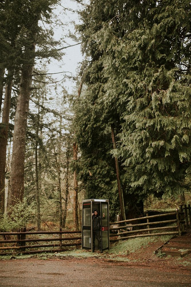 Man using outdoor phone booth in the mountains