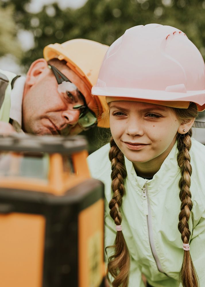 Girl learning from parent at a construction site