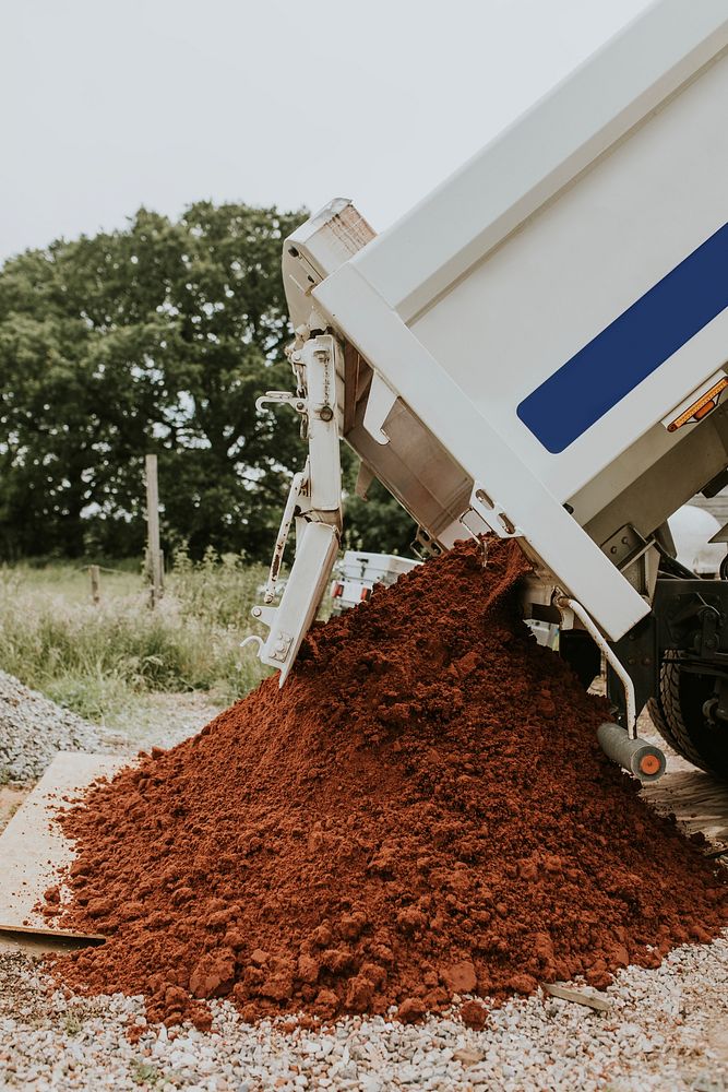 Sand truck unloading soil on a construction site