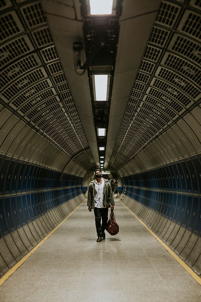 Man walking through underground tunnel 