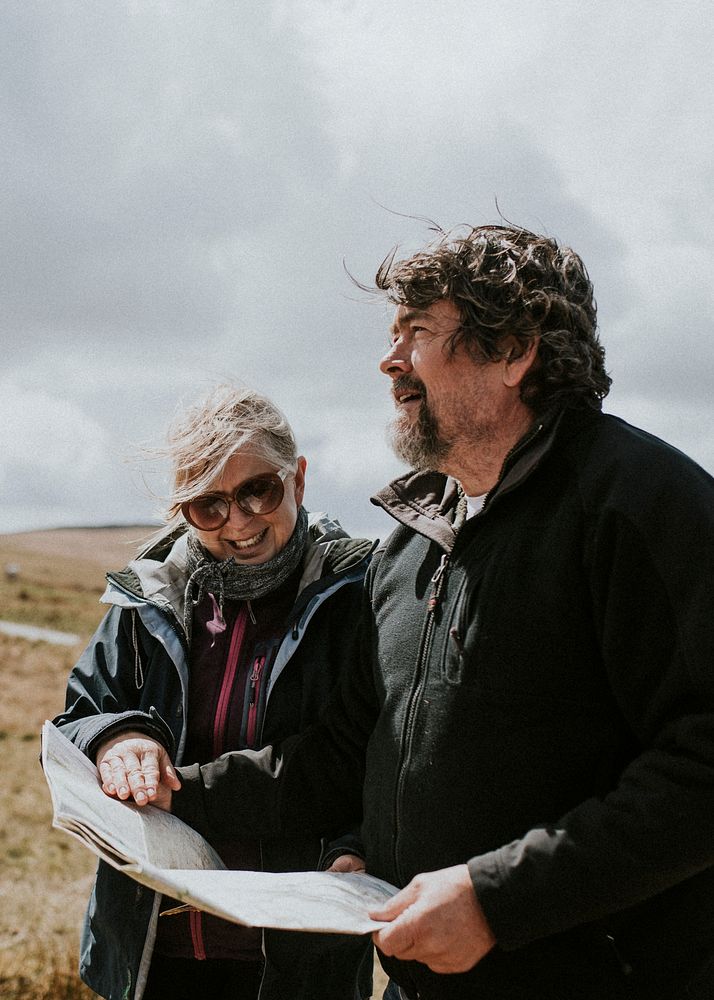 Senior tourist couple looking at the map while being lost in Wales, UK