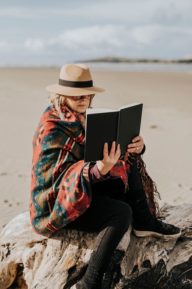Retired woman reading a book outdoors