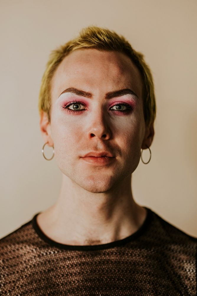 Blond non-binary person wearing makeup portrait