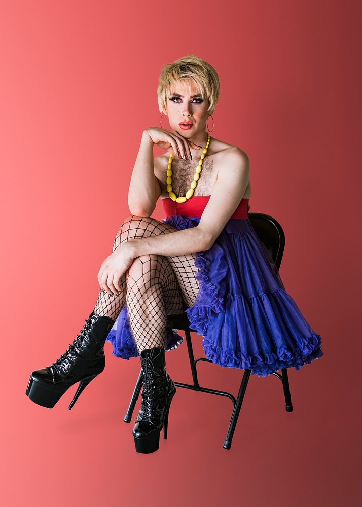 Beautiful blond drag queen psd, sitting on a chair