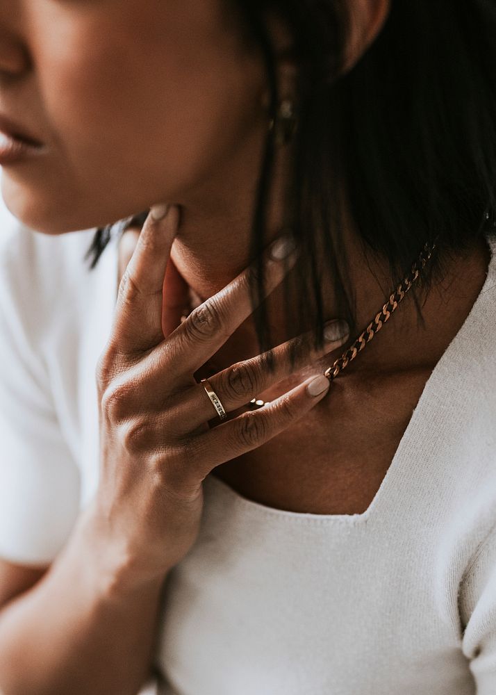 Woman touching her neck & gold necklace