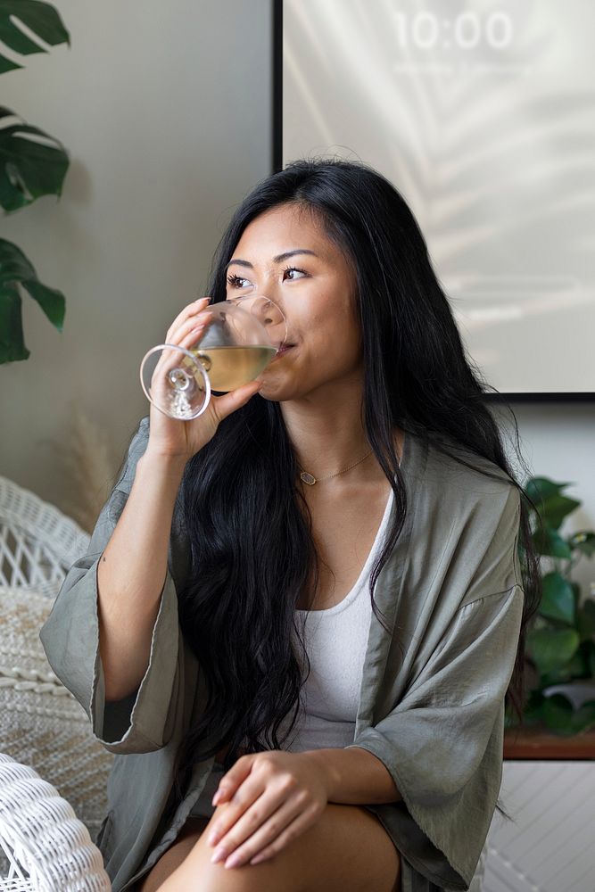 Woman drinking wine alone at home