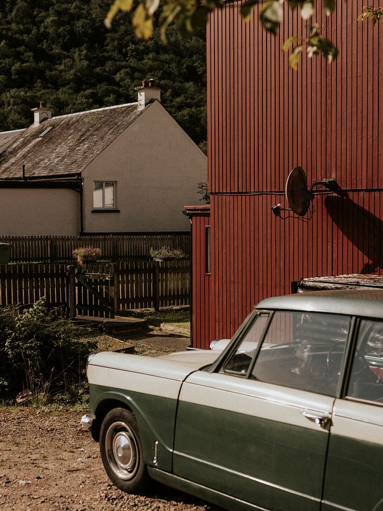 Vintage car parked by red wall