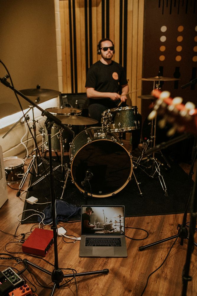 Rock band drummer performing repetition in recording studio