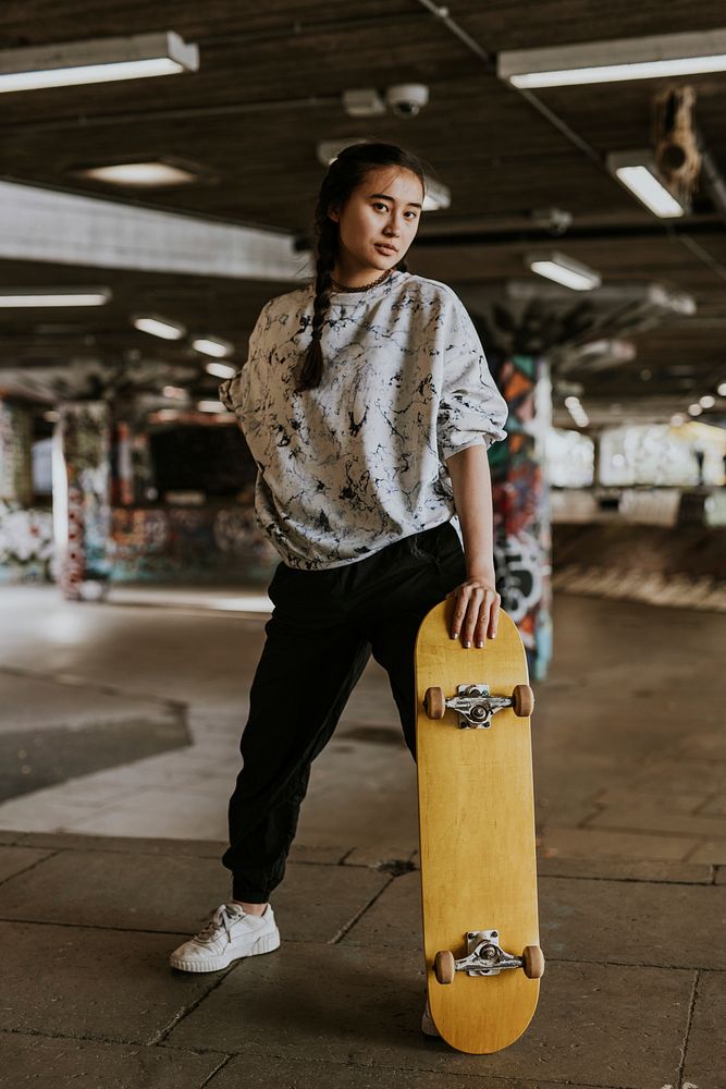 Cool Asian skater with wooden skateboard