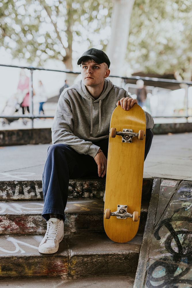 Skater sitting on steps with wooden skateboard