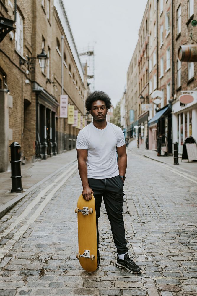 Man in city with yellow skateboard