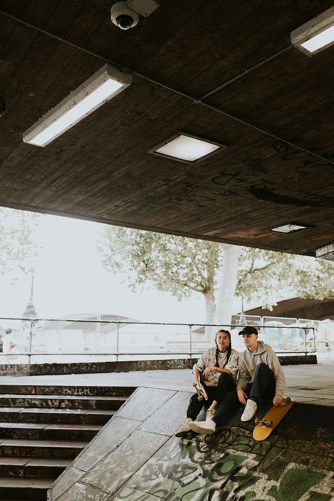 Cool skater sitting in skate park's slope