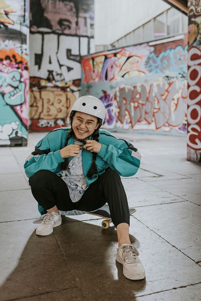 Happy Asian woman wearing skate helmet, sports safety equipment