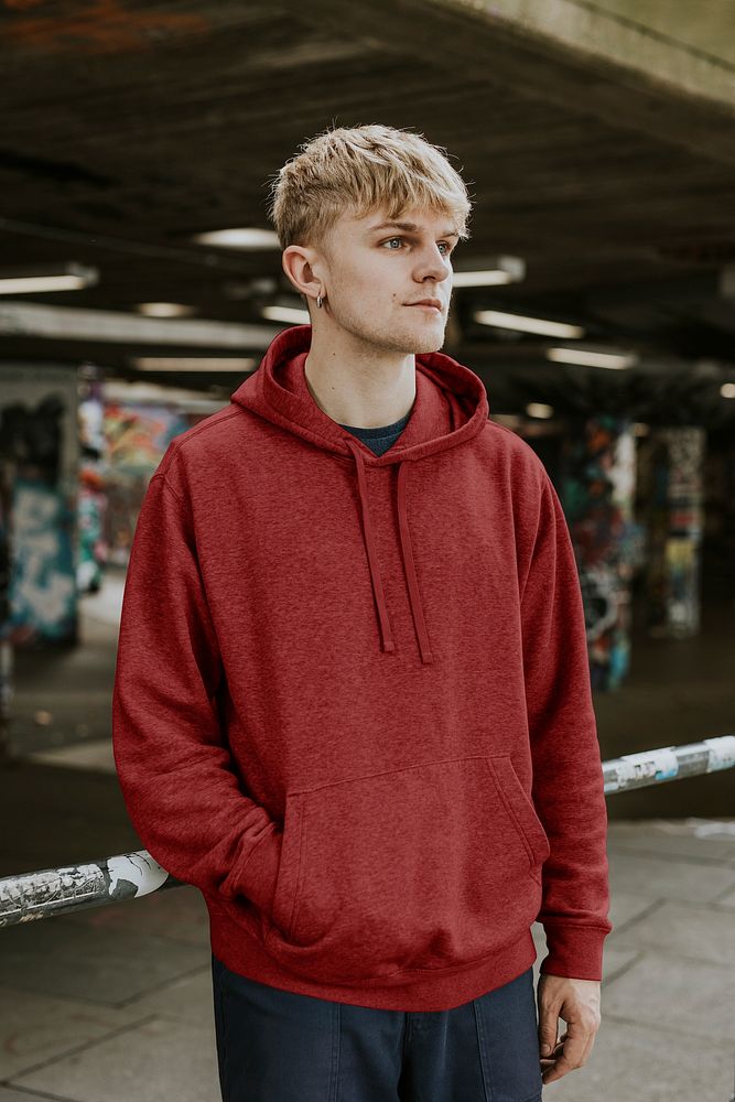 Blond man in red pullover hoodie at skate park